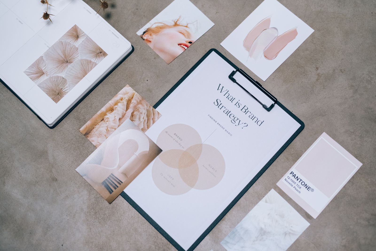 Brand strategy worksheet, colour swatches and moodboard prints laid out on a desk